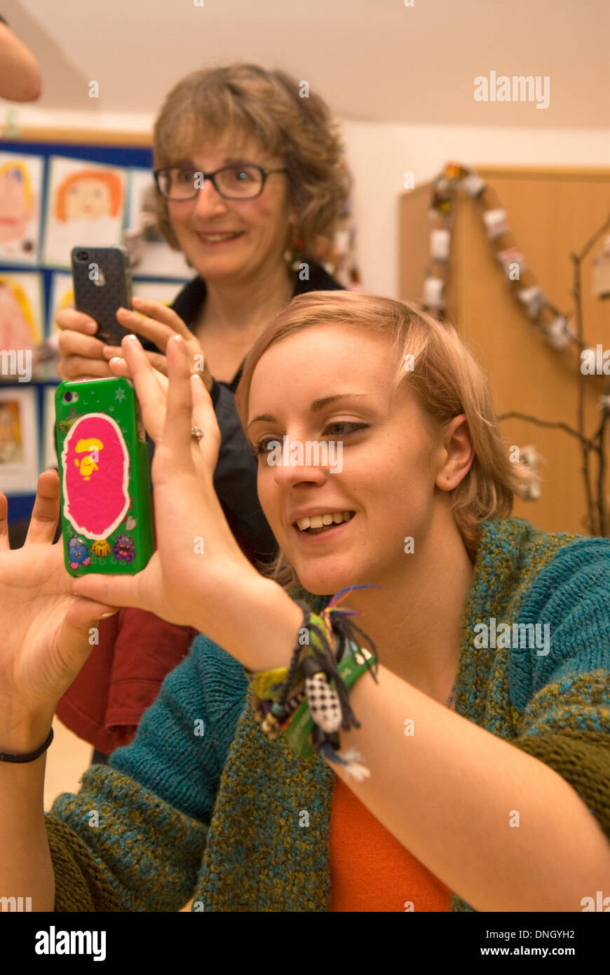 Eltern Aufnehmen von Bildern auf ihren Handys ihrer Kinder zu einem christmas Fayre, steil, in der Nähe von Petersfield, Hampshire, UK. Stockfoto