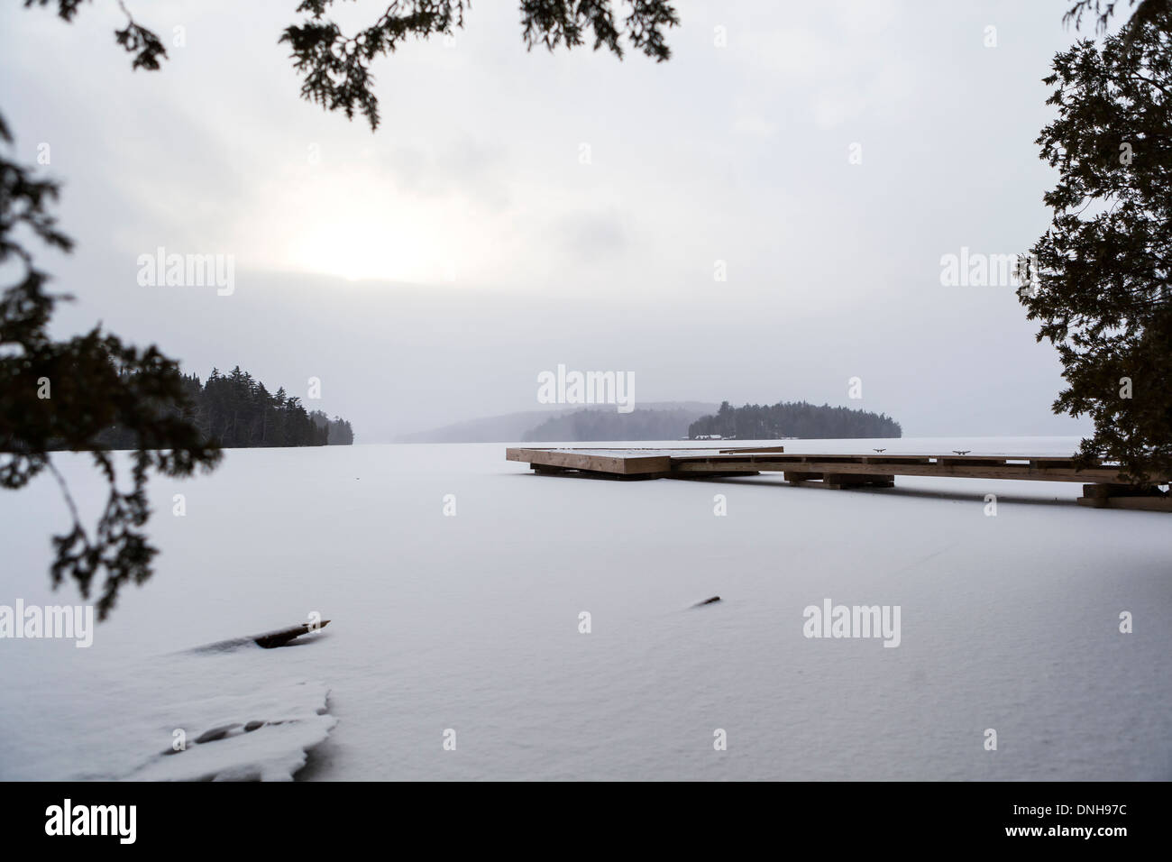 Hölzerne Pier auf dem zugefrorenen See Stockfoto