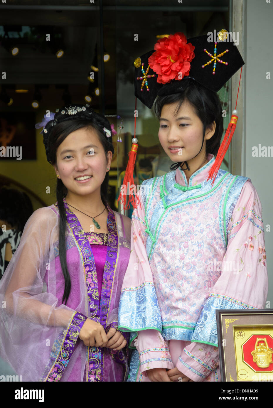 Chinesische Mädchen gekleidet in traditionellen Kleidern und Kopfbedeckungen. Stockfoto