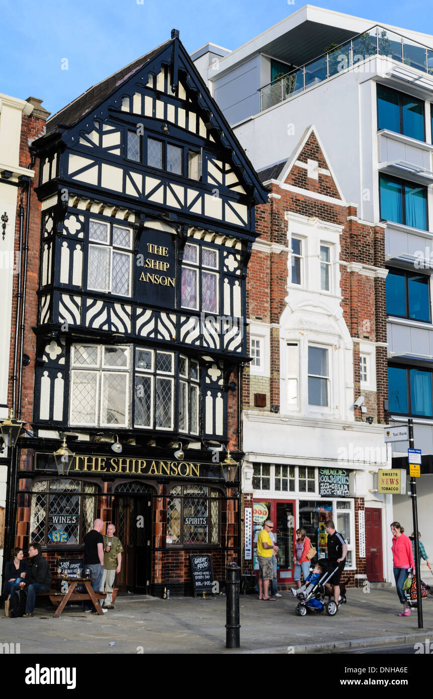 Typisch englisches Pub in schwarz und weiß (halb Fachwerkhaus)-Tudor-Stil, mit Kunden an einem warmen Sommertag draußen versammelt. Stockfoto