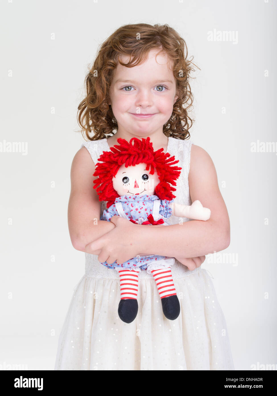 Raggedy Ann Kinderspielzeug von jungen Mädchen mit roten Haaren gehalten. Stockfoto