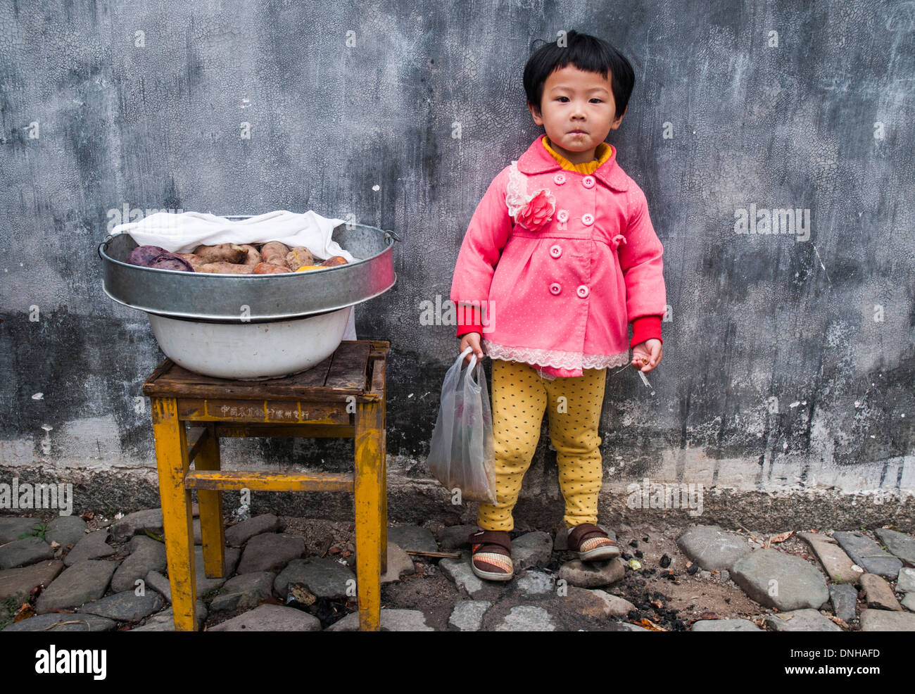 Kleines Mädchen mit einem Topf voll mit Lebensmitteln, Chengkan Dorf, Huizhou, Anhui, China Stockfoto