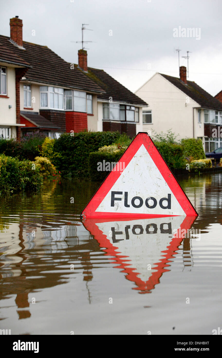 Ein Hochwasser Gefahr Warnzeichen ist im Wasser in der Nähe von überfluteten Häuser in Tewksbury abgebildet. Stockfoto