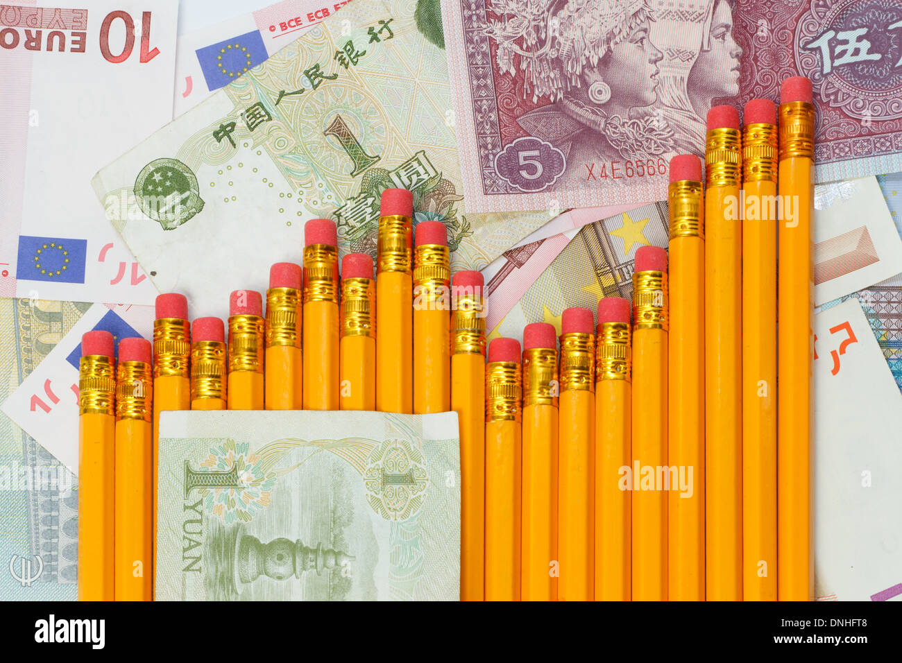 Steigender Graph Bleistifte vor Hintergrund der Yuan und Euro-Banknoten Stockfoto