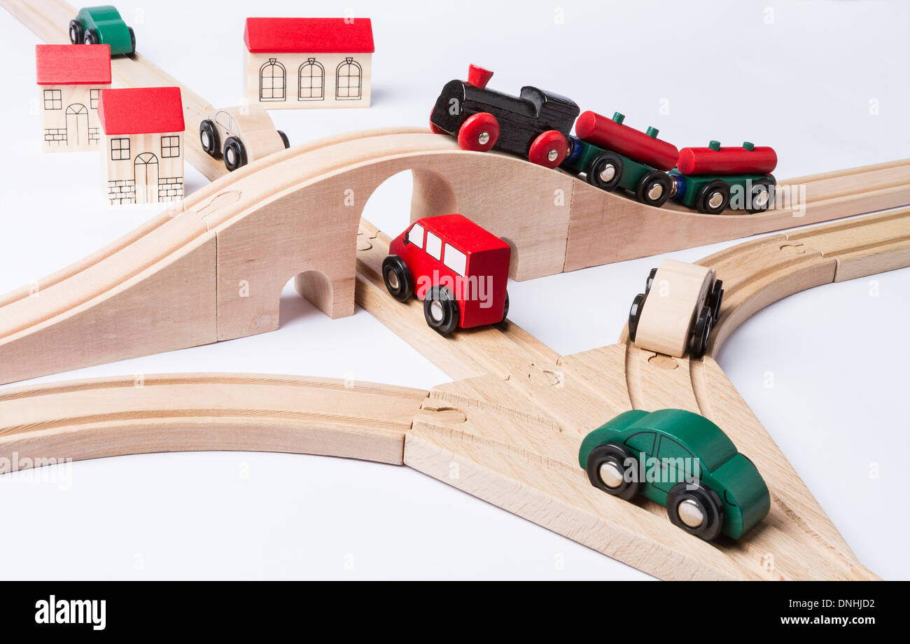 Schwerverkehr in der Nähe von kleinen Spielzeugstadt. Zug auf Brücke und einige Autos Stockfoto