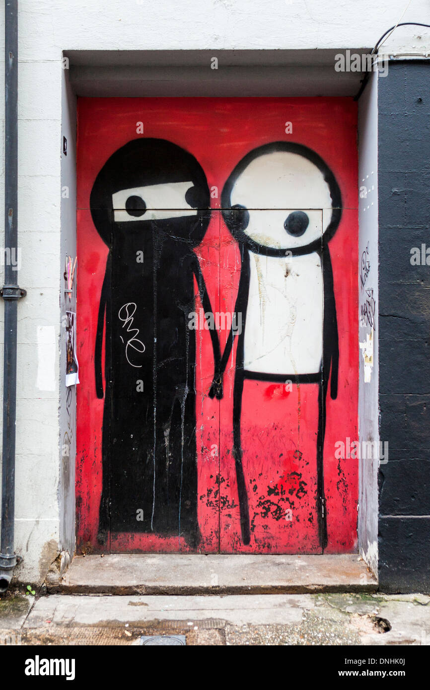 Streetart von Stik - Frau in traditioneller Kleidung und Mann - schwarz / weiß minimalistischen Figuren - Brick Lane, East London, UK Stockfoto