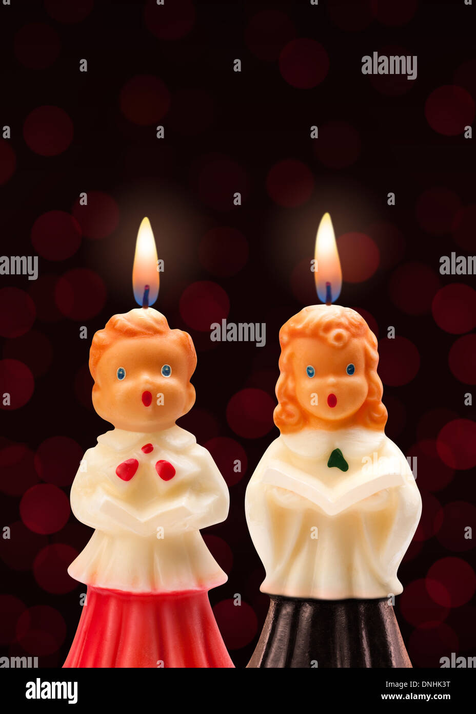 Chorknabe und Mädchen Kerzen auf einem dunklen Hintergrund isoliert. Stockfoto