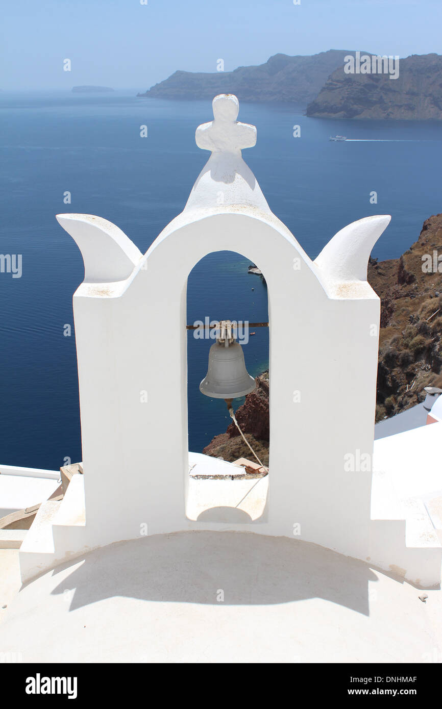 Ein Blick auf die Caldera von hinter einer traditionellen griechischen Kirche Bell auf der Insel Santorini, Griechenland Stockfoto