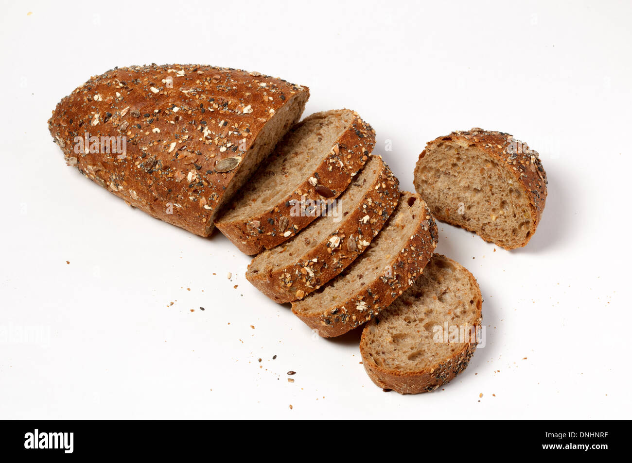 Scheiben vom rustikalen Kräuterbrot mit Samen auf weißem Hintergrund Stockfoto