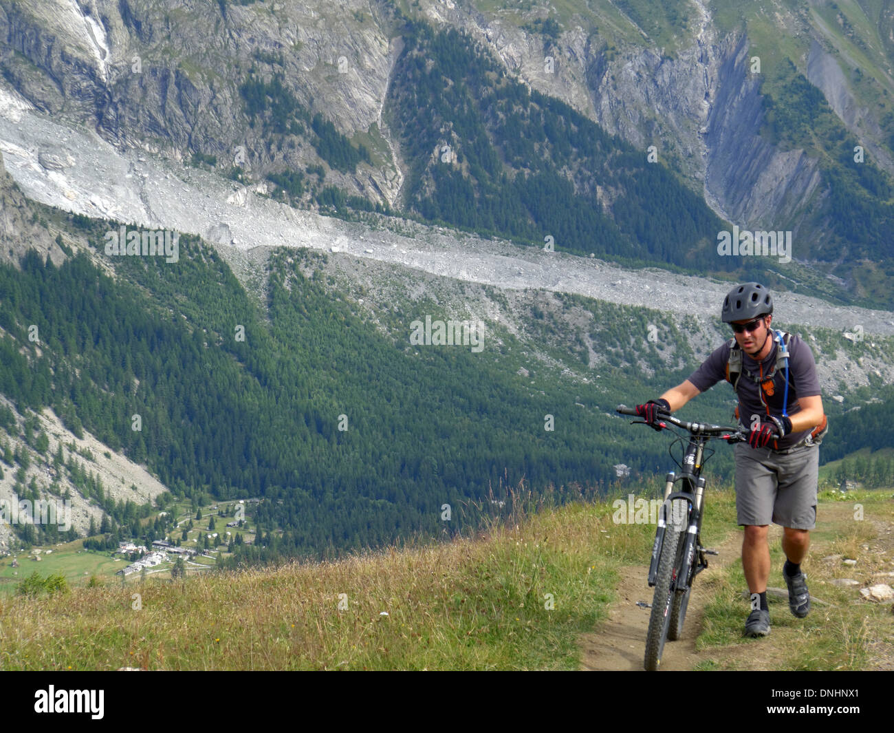 Mountainbiker, schob sein Fahrrad auf die Tour de Mont Blanc Stockfoto