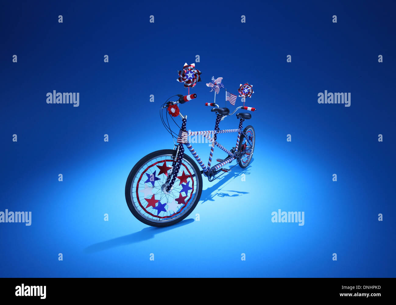 Ein Zwilling sitzen Fahrrad mit rot-weiß blau Dekorationen auf blauem Grund. Stockfoto