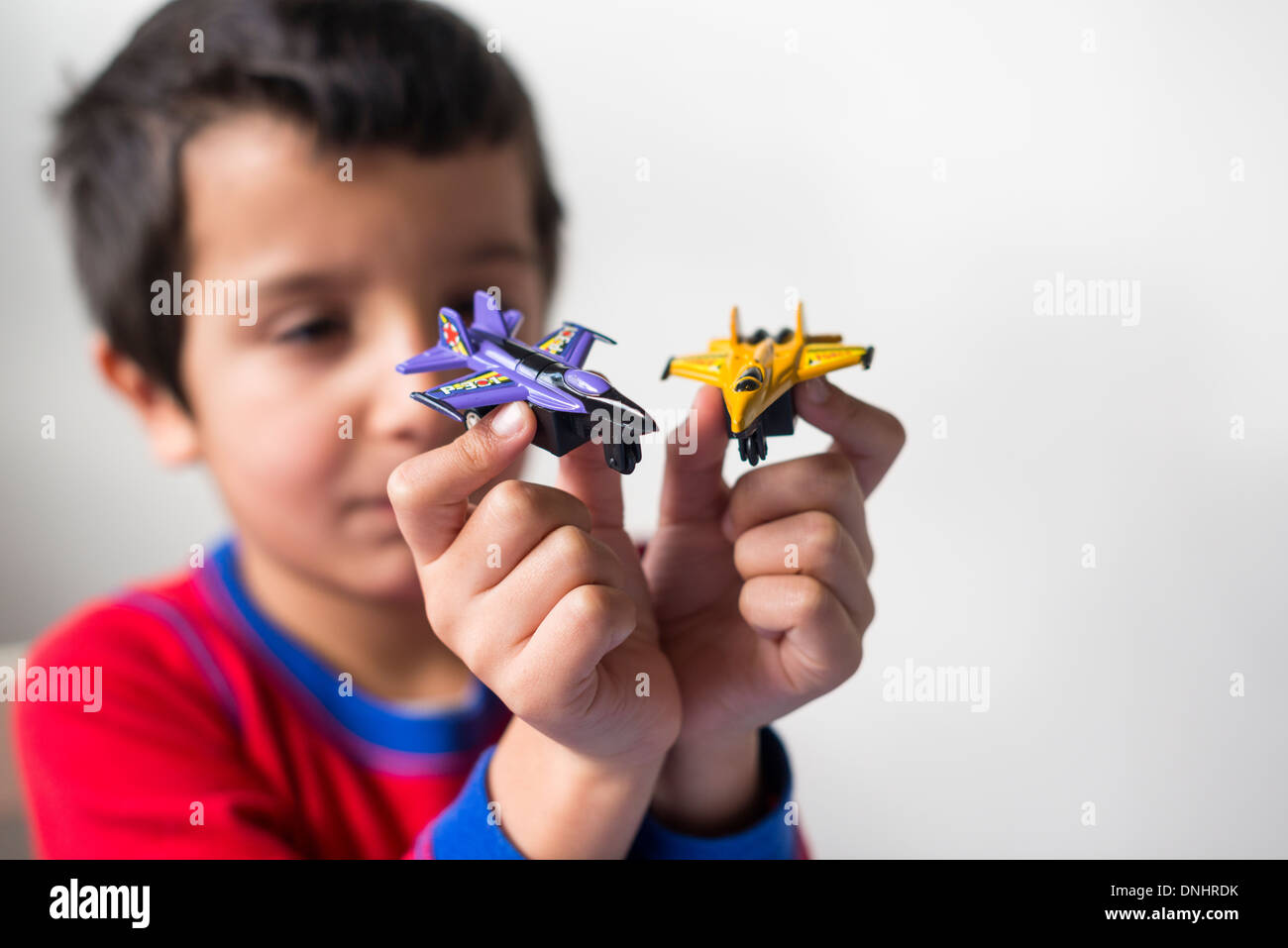 Junge spielt mit zwei Spielzeug Flugzeuge Stockfoto