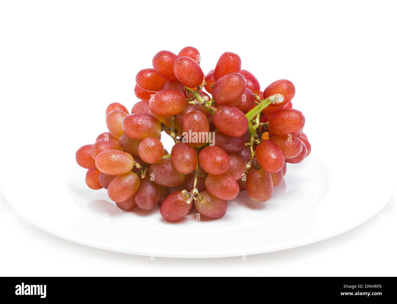 Frische rote Weintrauben auf weißem Hintergrund. Stockfoto