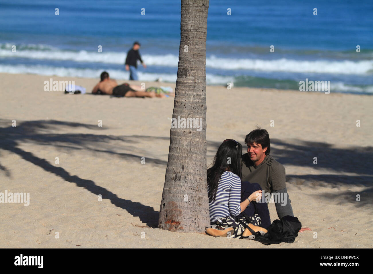 Junger Mann und Frau unter Palme am Strand von ft. Lauderdale, Florida. Stockfoto