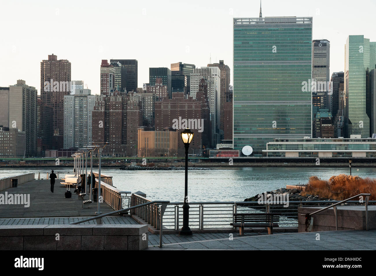 Läufer bei einem der Piers von Gantry State Park in Long Island City mit Blick auf den East River und dem UN-Hauptquartier Stockfoto