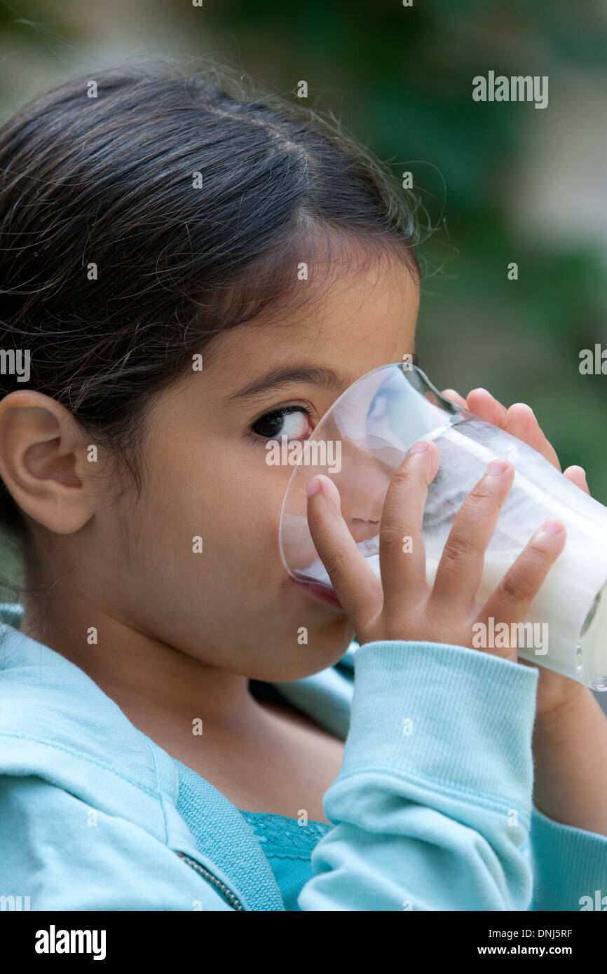 Kleines Mädchen ist aus einem Glas Milch trinken. Stockfoto