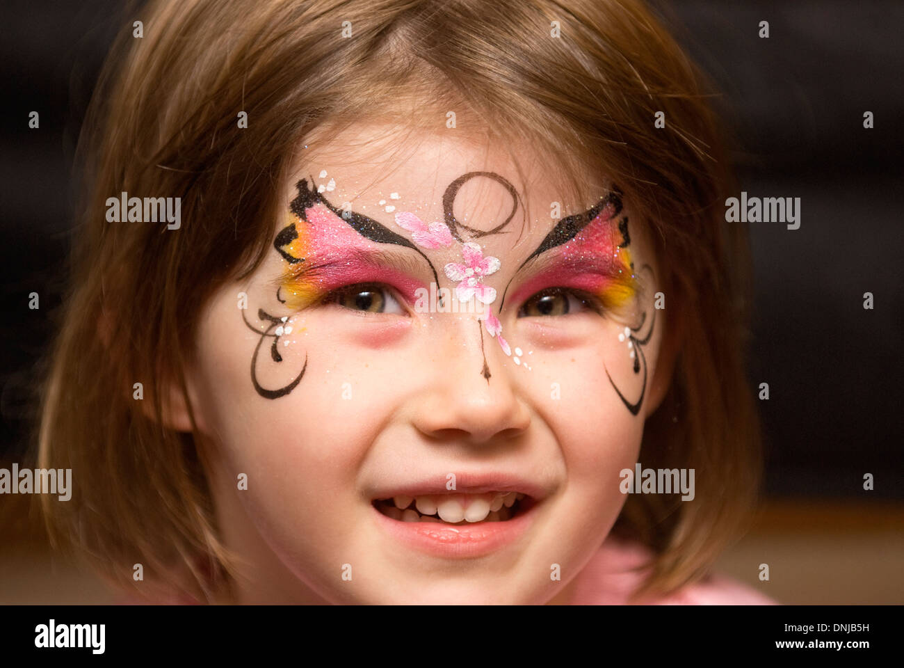 4 Jahre altes Mädchen mit ihrem Gesicht an einer Familie gemalt Weihnachtsfeier, Haslemere, Surrey, Großbritannien. Stockfoto