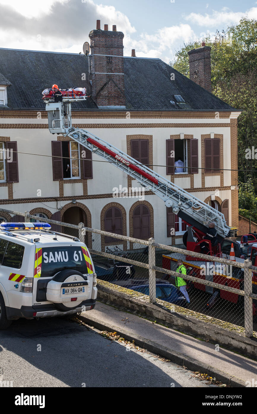 EIN OPFER MIT DER FEUERWEHR LEITER EVAKUIEREN, WÄHREND SAMU (RETTUNGSDIENST) ÄRZTE WARTEN, RUGLES, EURE (27), FRANKREICH Stockfoto