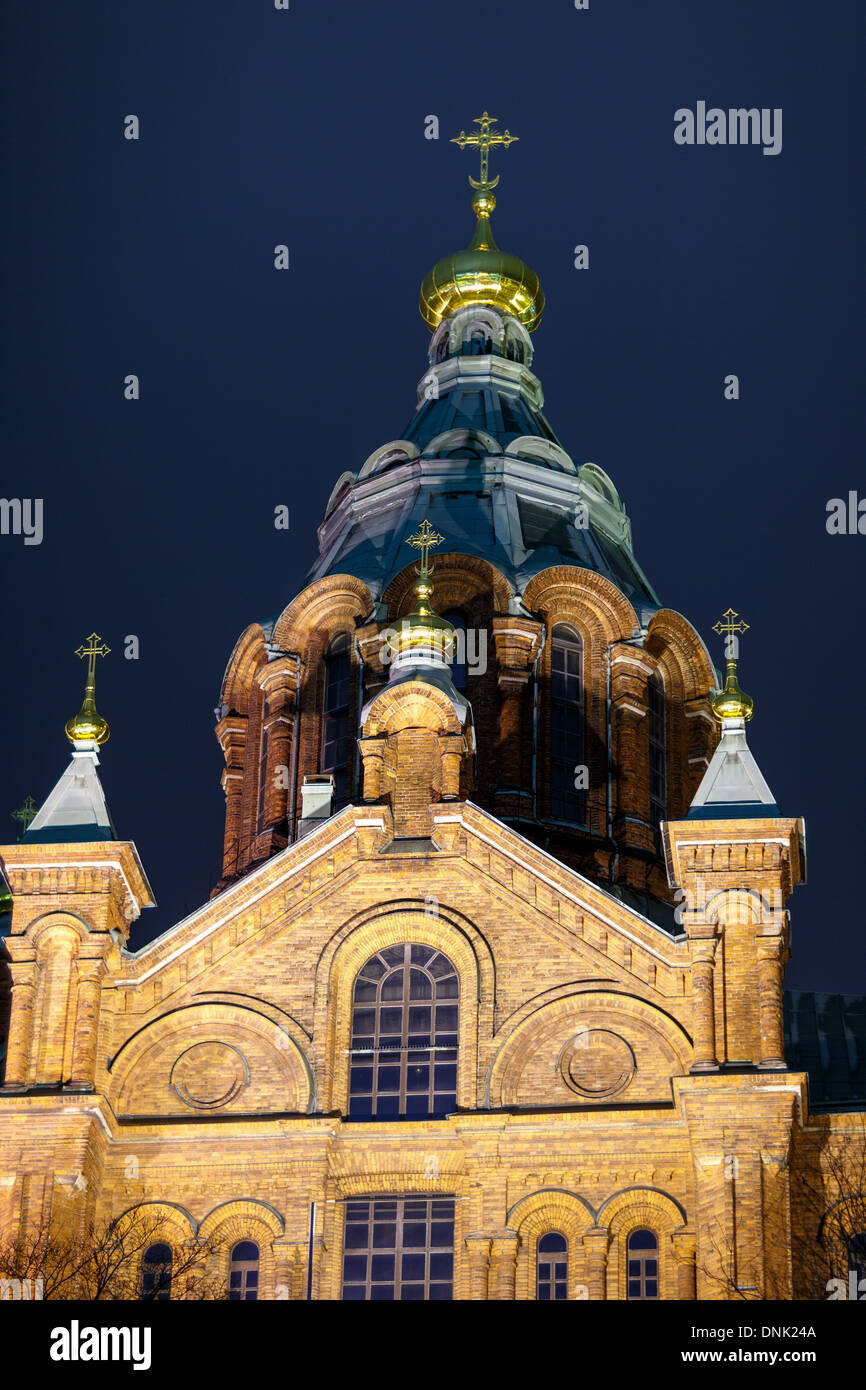 Westfassade des östlichen orthodoxen Uspenski Kathedrale von Helsinki beleuchtet vor dunklen Nachthimmel. Stockfoto