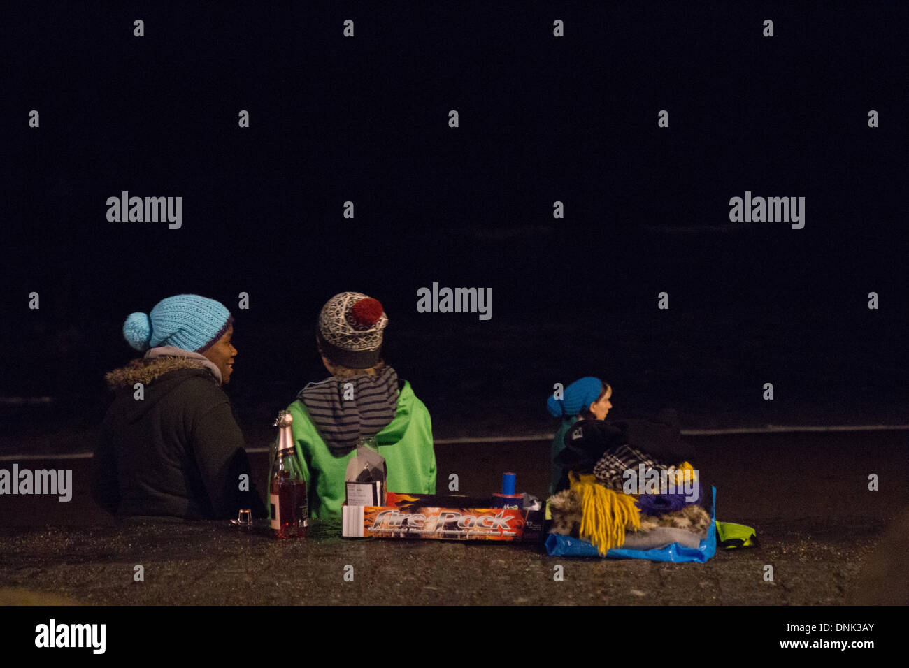 Aberystwyth, Wales, UK. 1. Januar 2014. Silvester am Strand in Aberystwyth mit rosa Sekt & Feuerwerk Credit: Jon Freeman/Alamy Live News Stockfoto