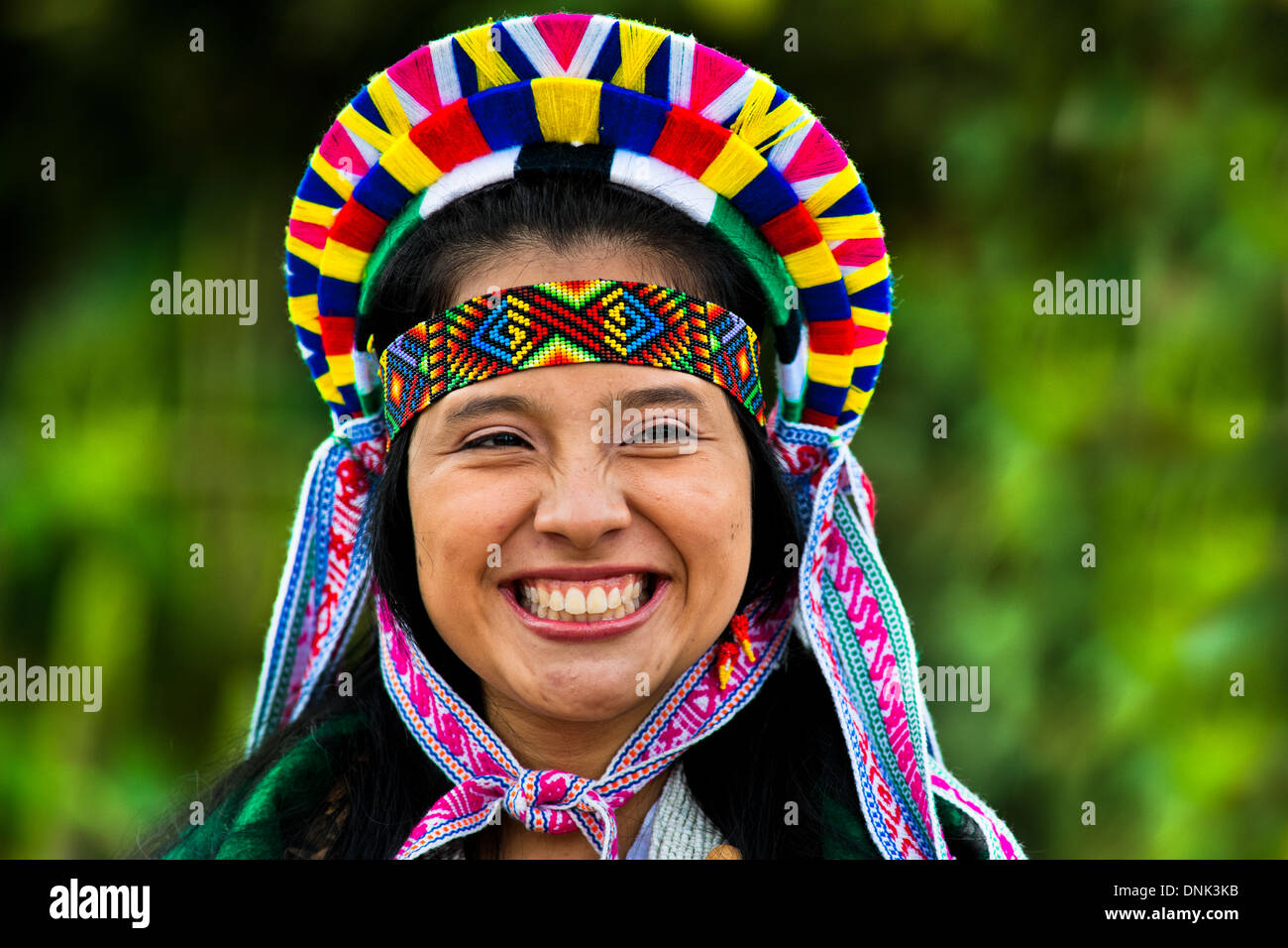 Ein Einheimischer aus der Kamentsá Stamm, trägt einen bunten Kopfbedeckungen, lächelt während des Karnevals der Vergebung in Sibundoy, Kolumbien. Stockfoto