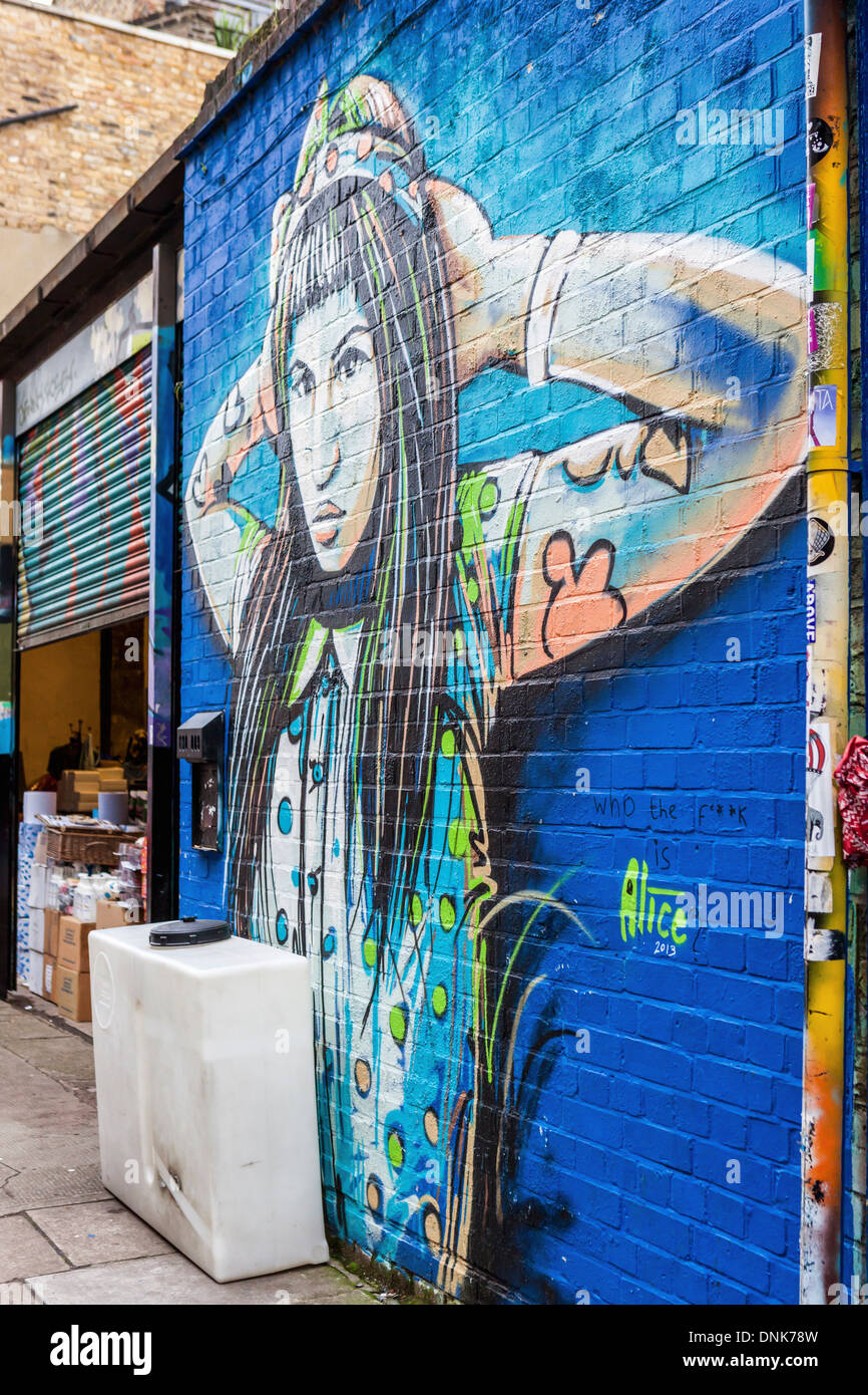 Wandbild Streetart von Alice Pasquini - eine farbige Frau mit langen schwarzen Haaren, East London, UK Stockfoto