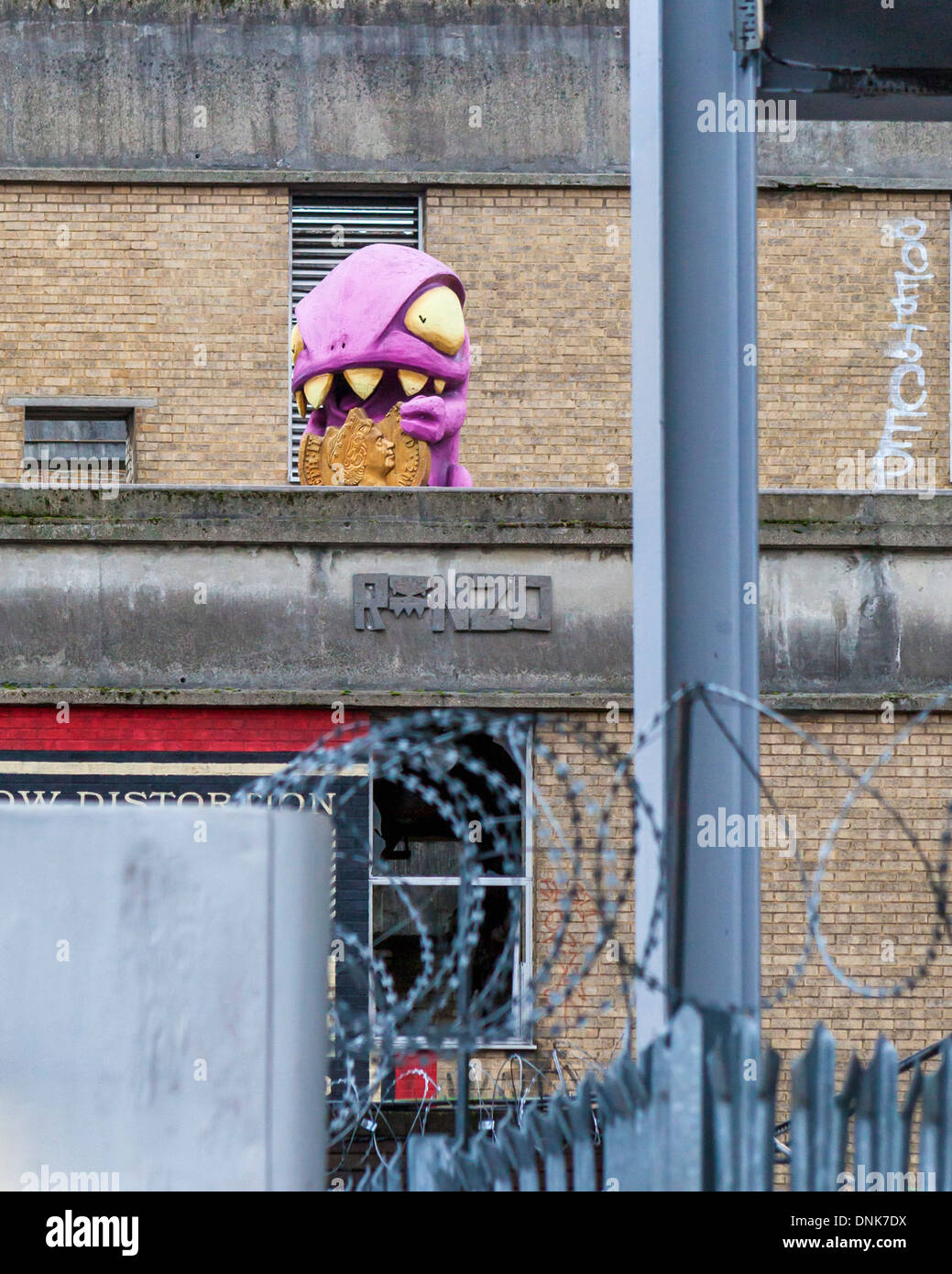 Street-Art - ein Kunstwerk von Ronzo, rosa, Zahnlücken Credit Crunch Monster auf einem Dach im Bereich Brick Lane, East London, UK Stockfoto