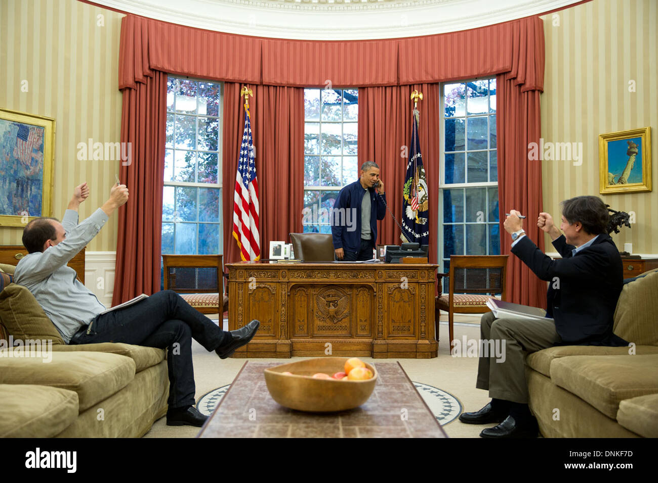 Ben Rhodes und Tony Blinken beide Daumen aufgeben als uns Präsident Barack Obama von Außenminister John Kerry in Genf am Telefon hört, die ein Abkommen mit dem Iran im Oval Office 23. November 2012 in Washington, DC erreicht wurde. Stockfoto