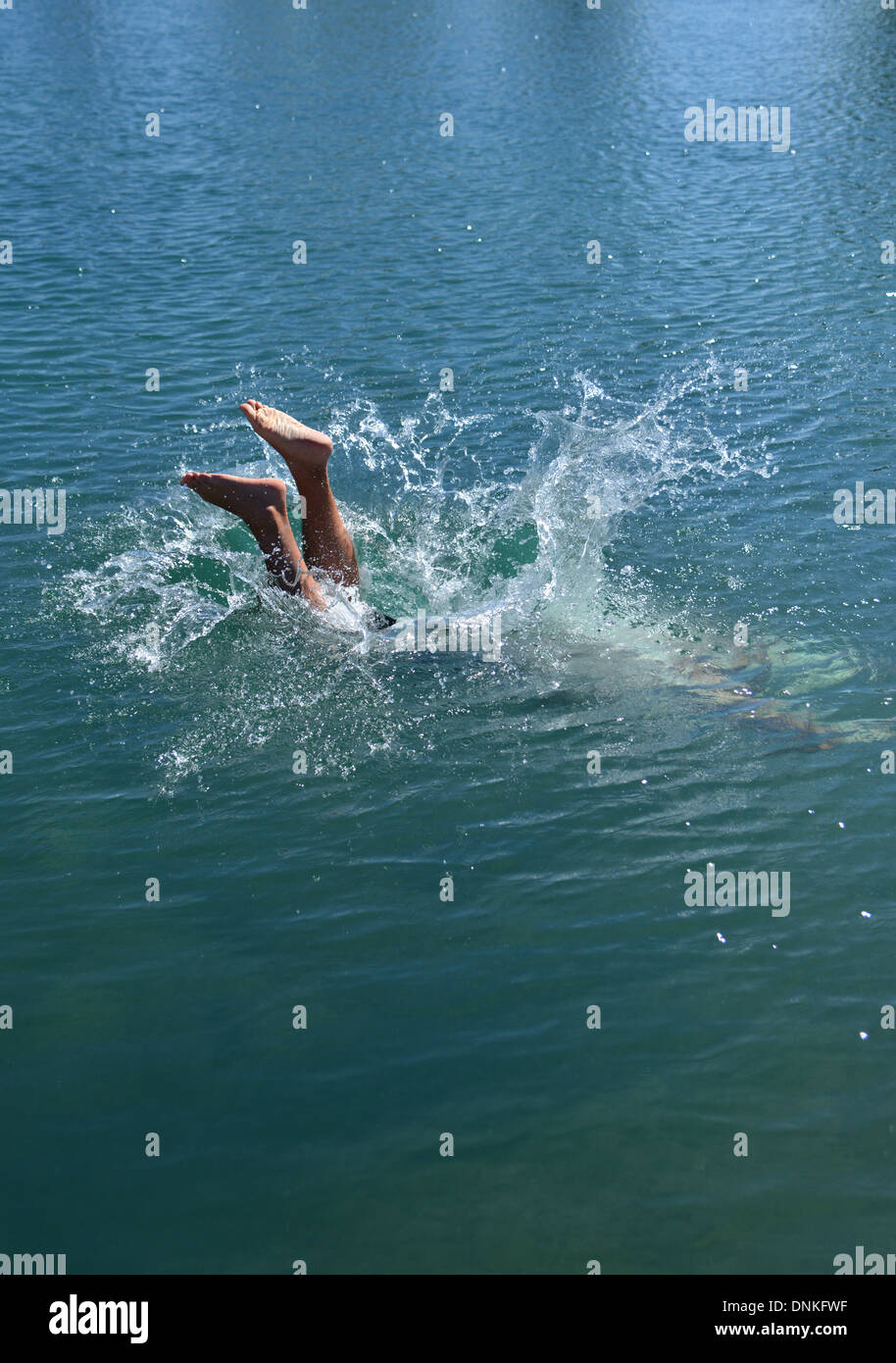 Jump in! Eintauchen in einen Außenpool, nur Füße aus dem Wasser zeigt Mann Stockfoto