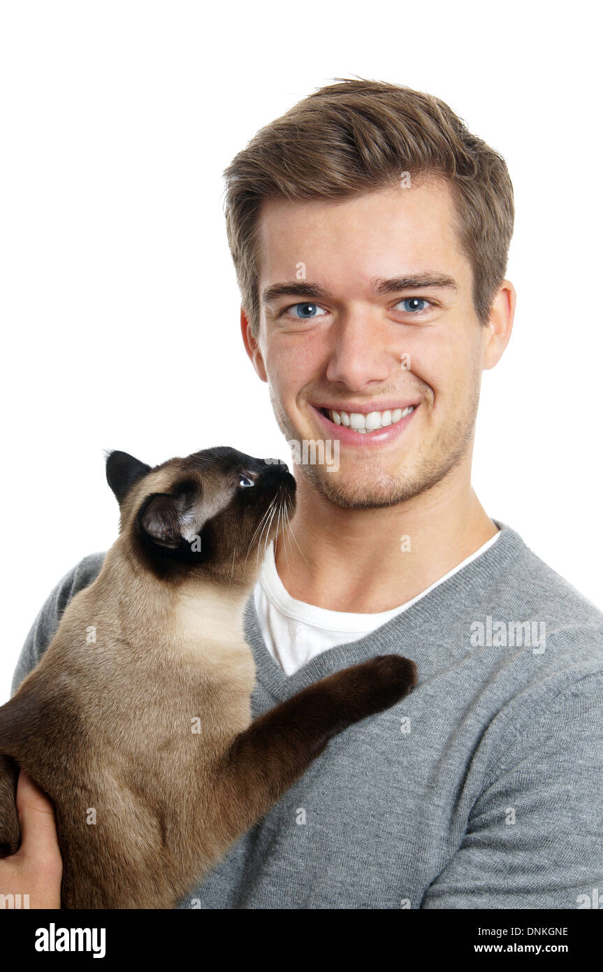 jungen Mann, der siamesische Katze hält lächelnd Stockfoto