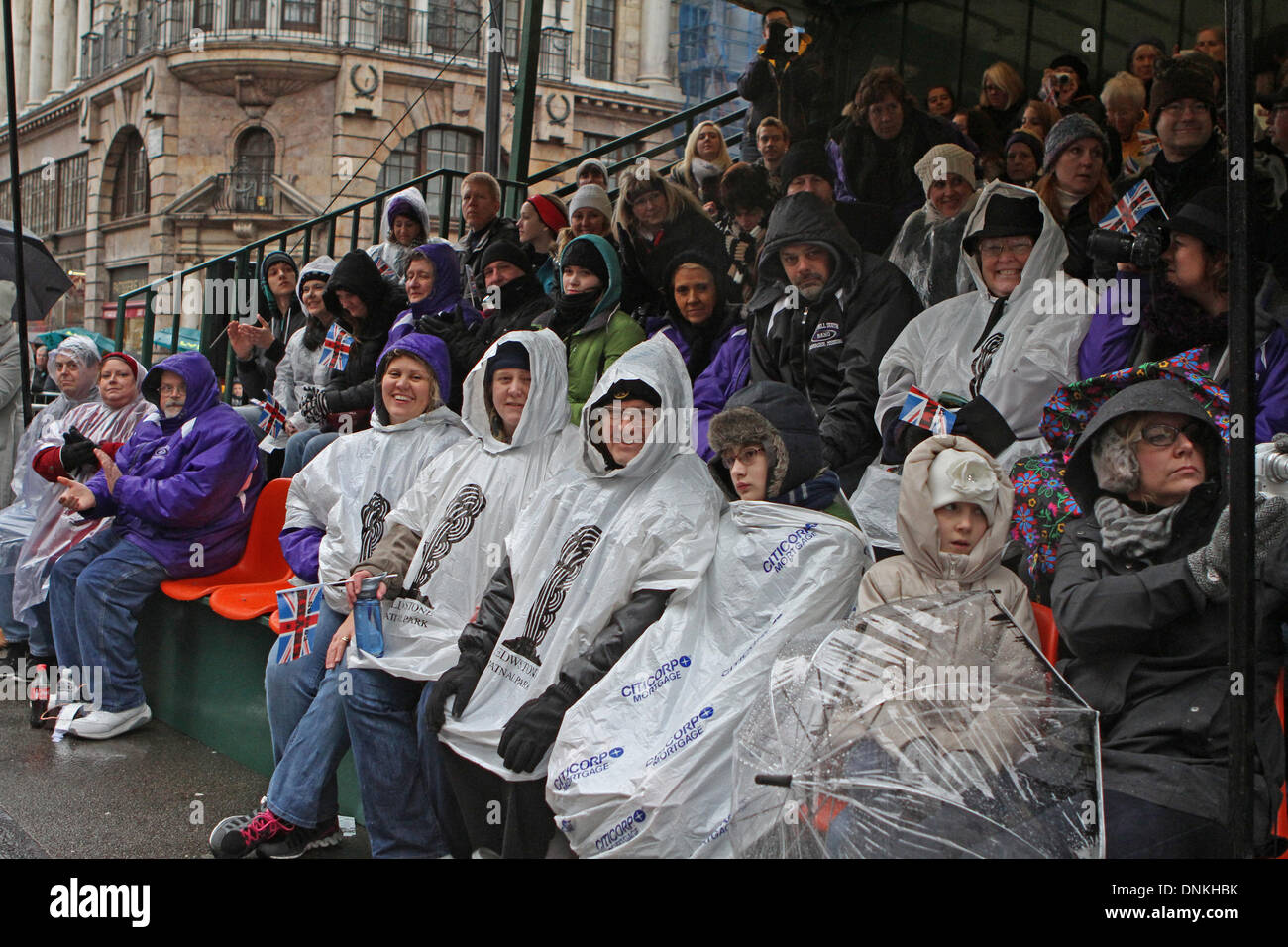 London, UK, 1. Januar 2014, Massen tragen Ponchos aus dem Regen zu halten, während warten auf der Londons New Year es Day Parade 2014 Kredit ist: Keith Larby/Alamy Live News Stockfoto
