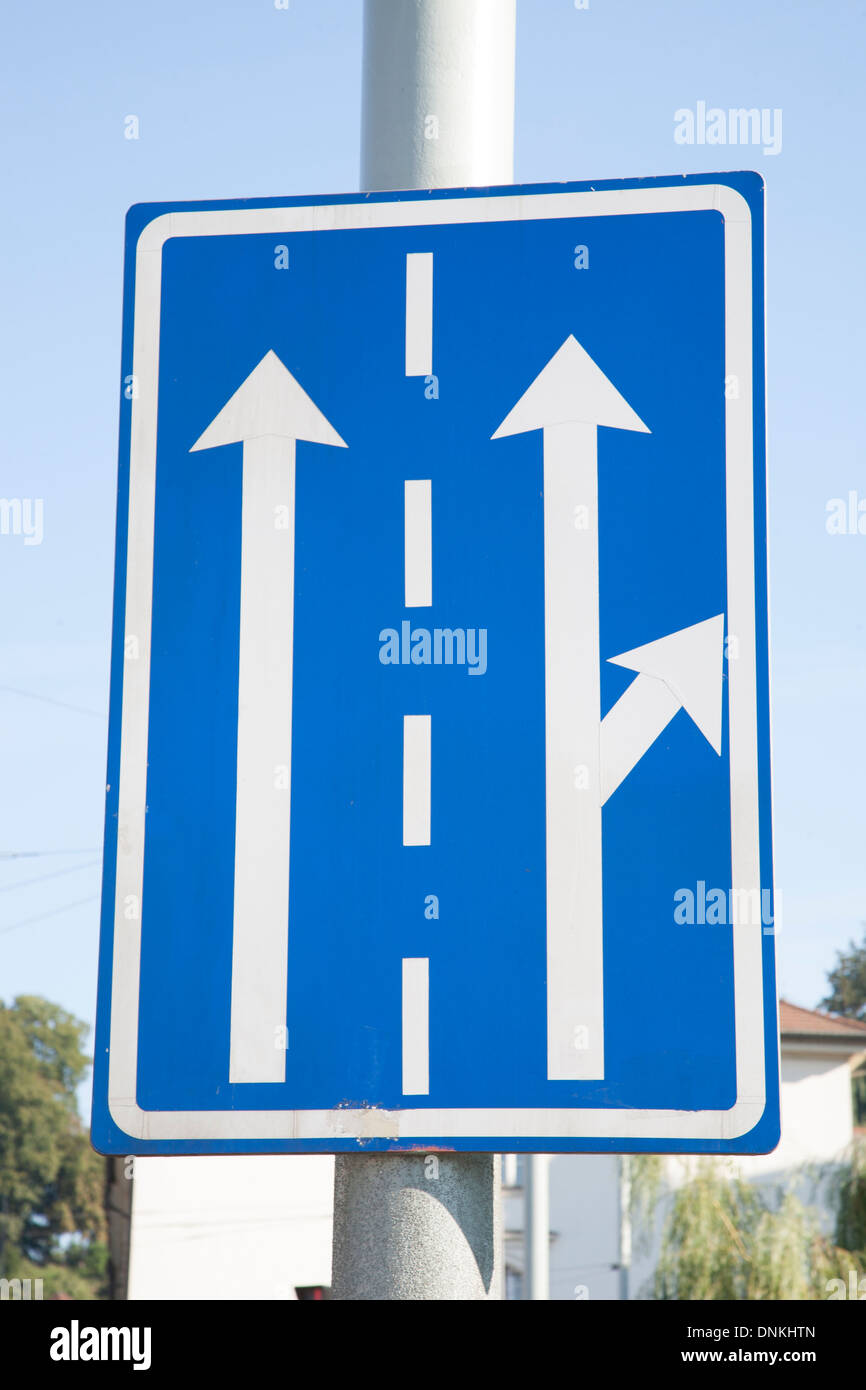 Blauer Pfeil Richtung Verkehrszeichen auf blauen Himmelshintergrund Stockfoto