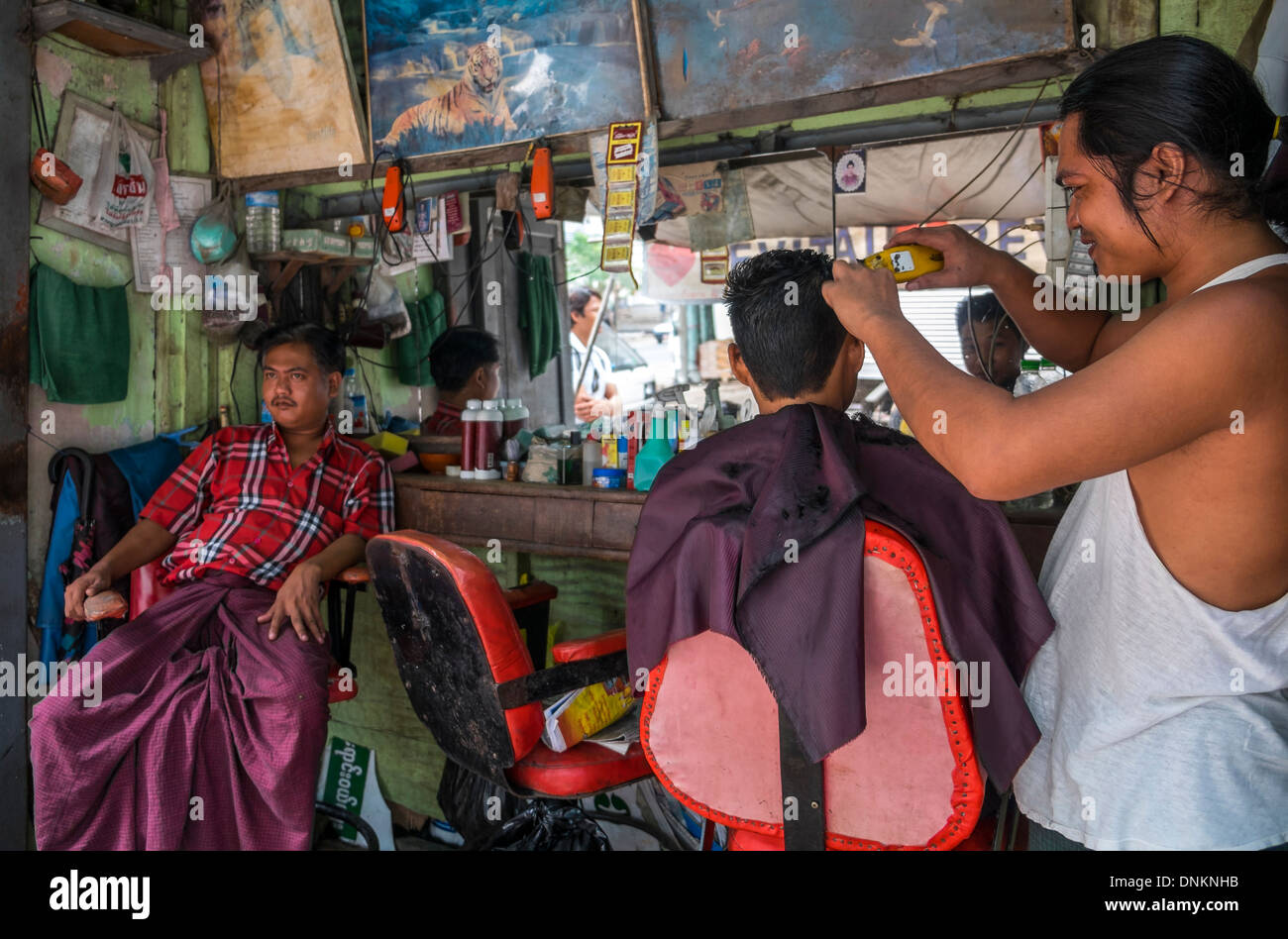 YANGON, MYANMAR - ca. Dezember 2013: Barbershop in den Straßen von Yangon. Stockfoto