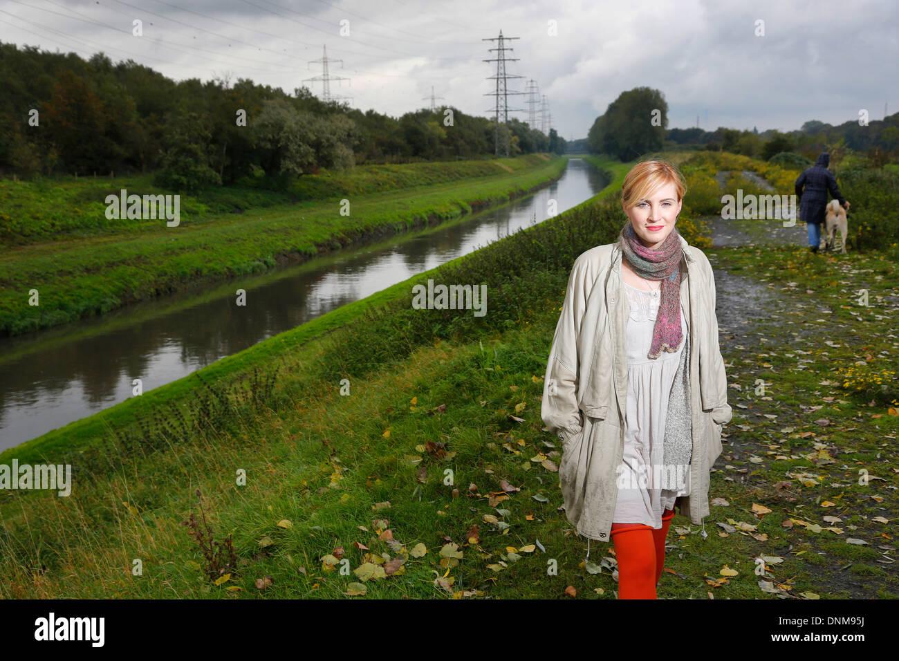 Oberhausen, Deutschland, geht eine junge Frau für einen Spaziergang im Regen an der Emscher Stockfoto