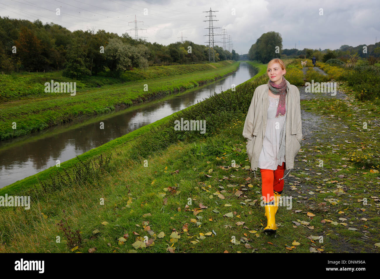 Oberhausen, Deutschland, geht eine junge Frau für einen Spaziergang im Regen an der Emscher Stockfoto