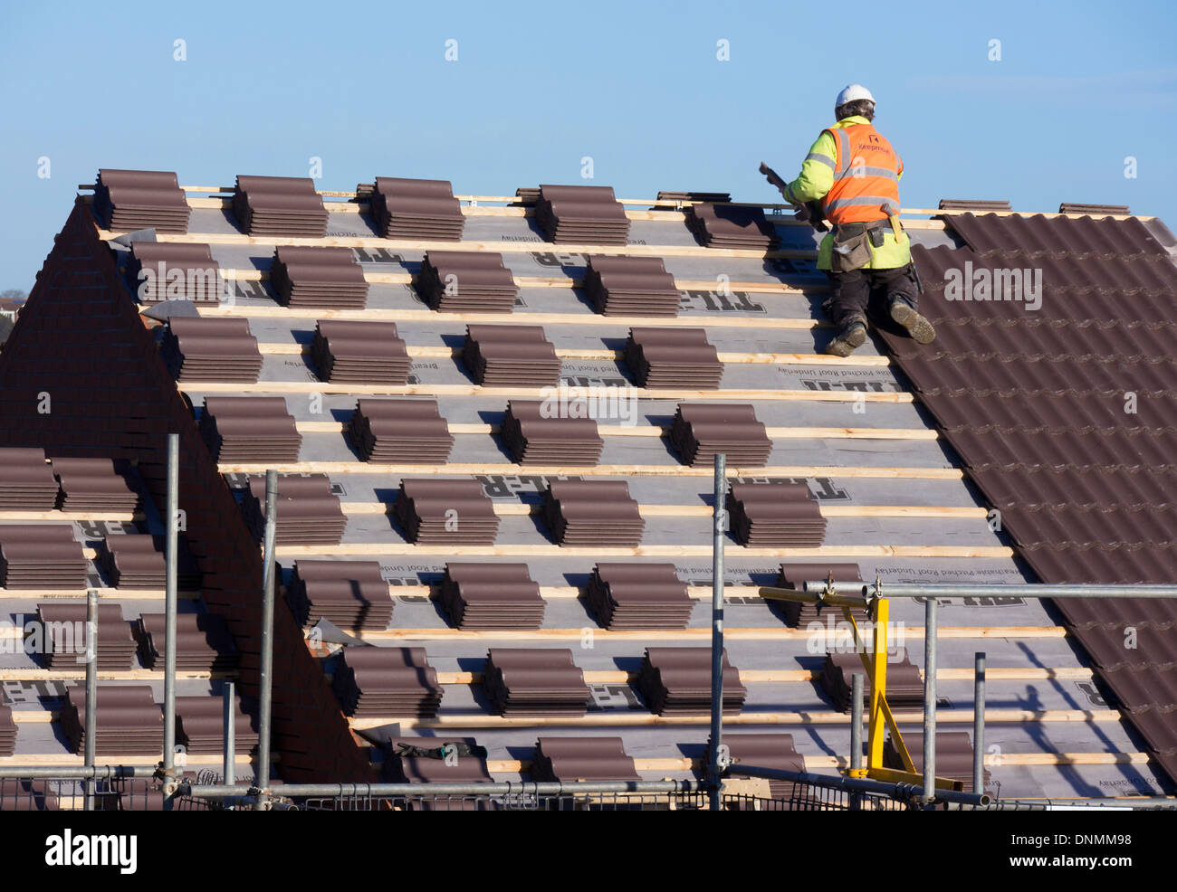 Mann, die Verlegung von Dachziegeln auf neue Wohnhäuser, Grantham, Lincolnshire Stockfoto