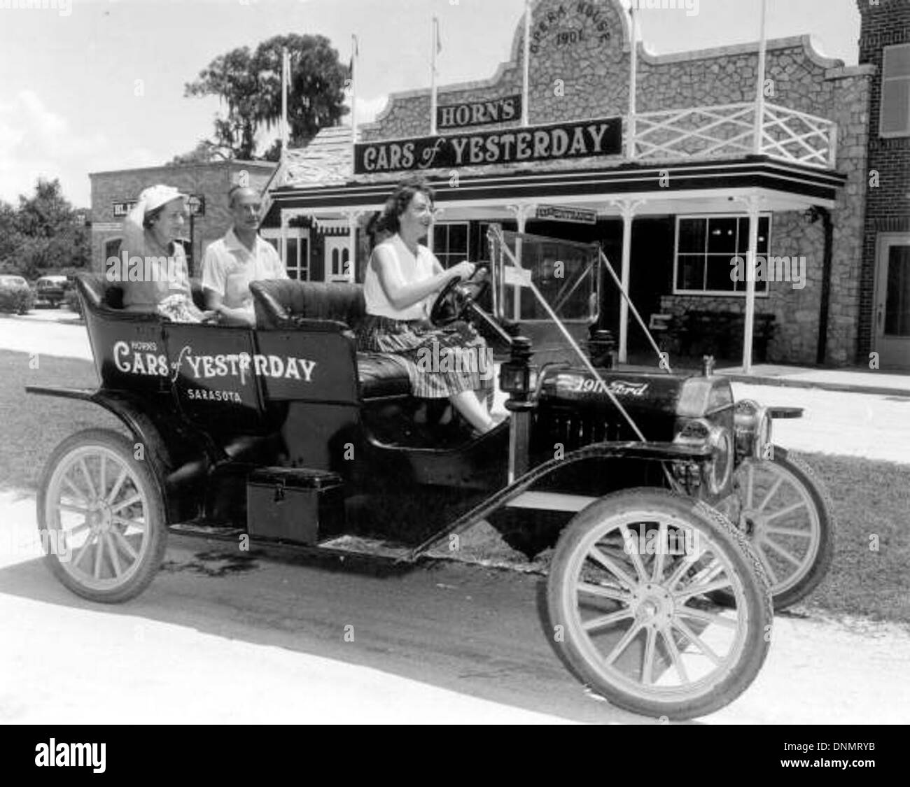 Besucher werden vor dem Museum Horn's Cars of gestern in Sarasota, Florida, mit antiken Autos gesehen. Das Foto spiegelt das Interesse der 1950er Jahre an Oldtimern und Tourismus im Sarasota County wider. Stockfoto