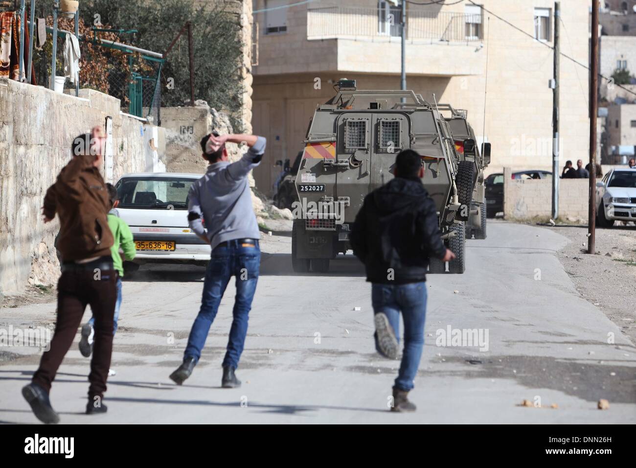 Bethlehem. 2. Januar 2014. Palästinensische Jugendliche schleudern Steinen in Richtung der israelischen Armeefahrzeuge bei einer Razzia in der West Bank von Bethlehem auf 2. Januar 2014. Mindestens zwei Palästinenser wurden bei der Razzia verhaftet palästinensischen Quellen sagten. Bildnachweis: Luay Sababa/Xinhua/Alamy Live-Nachrichten Stockfoto