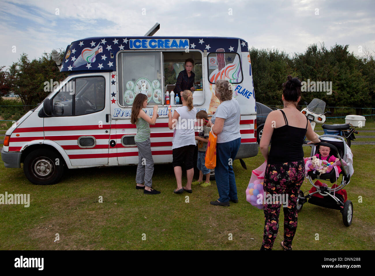Menschen im Bereich Kauf Eis an englischen Sommertag an einem Boot Messe in der Nähe von Hastings, UK Stockfoto