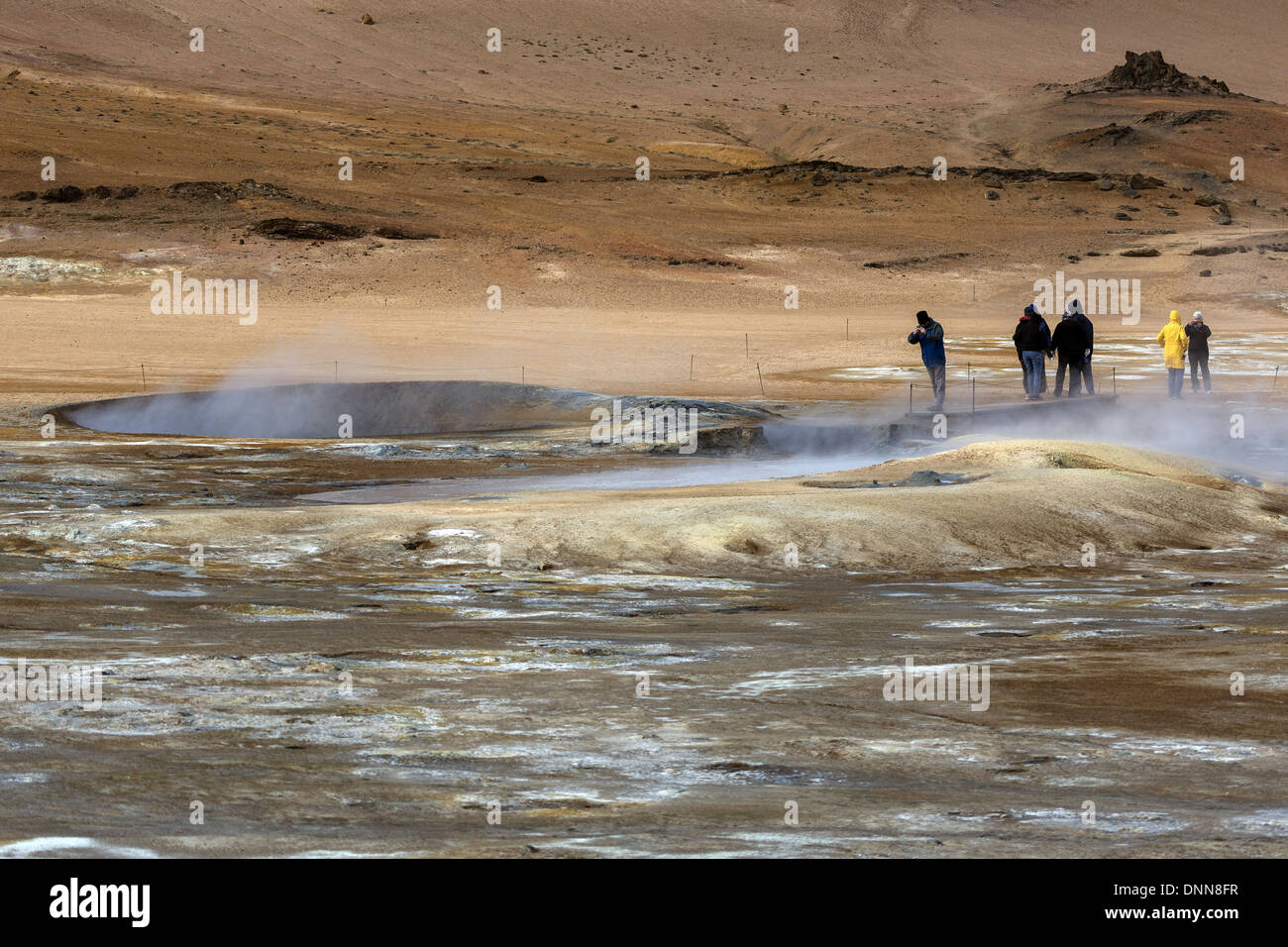 Touristen im Bereich Geothermie Sprudel Hverarond, untersuchen den dampfenden und brodelte Schlamm Becken, Nord-Ost-Island Stockfoto