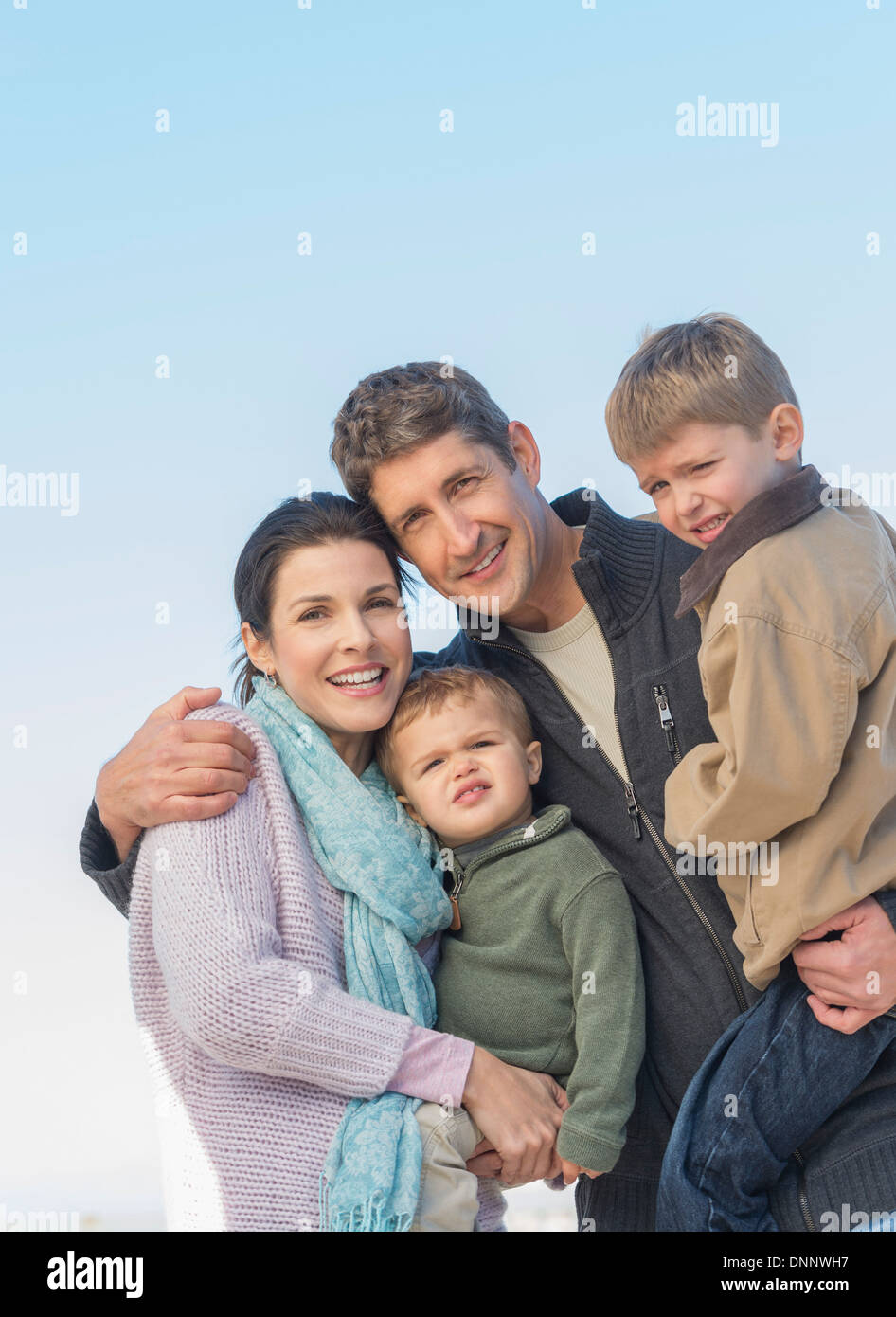 Eltern mit Kindern (12-17 Monate, 6-7) unter blauem Himmel Stockfoto