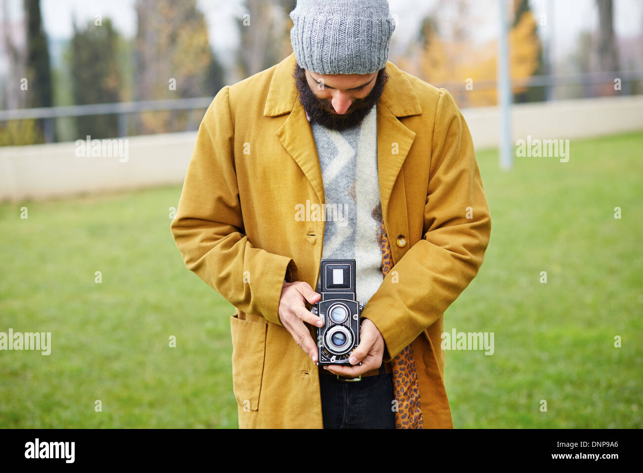 Junge bärtige Hipster Aufnahme mit TLR Kamera im freien Stockfoto
