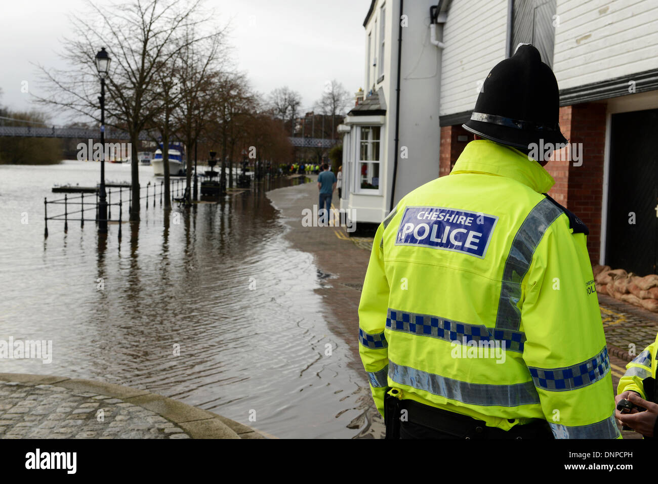 Chester, UK. 3. Januar 2014. Ein Polizist beobachtet die Flut auf den Fluss Dee in The Groves in Chester Stadtzentrum entfernt. Bildnachweis: Andrew Paterson/Alamy Live-Nachrichten Stockfoto