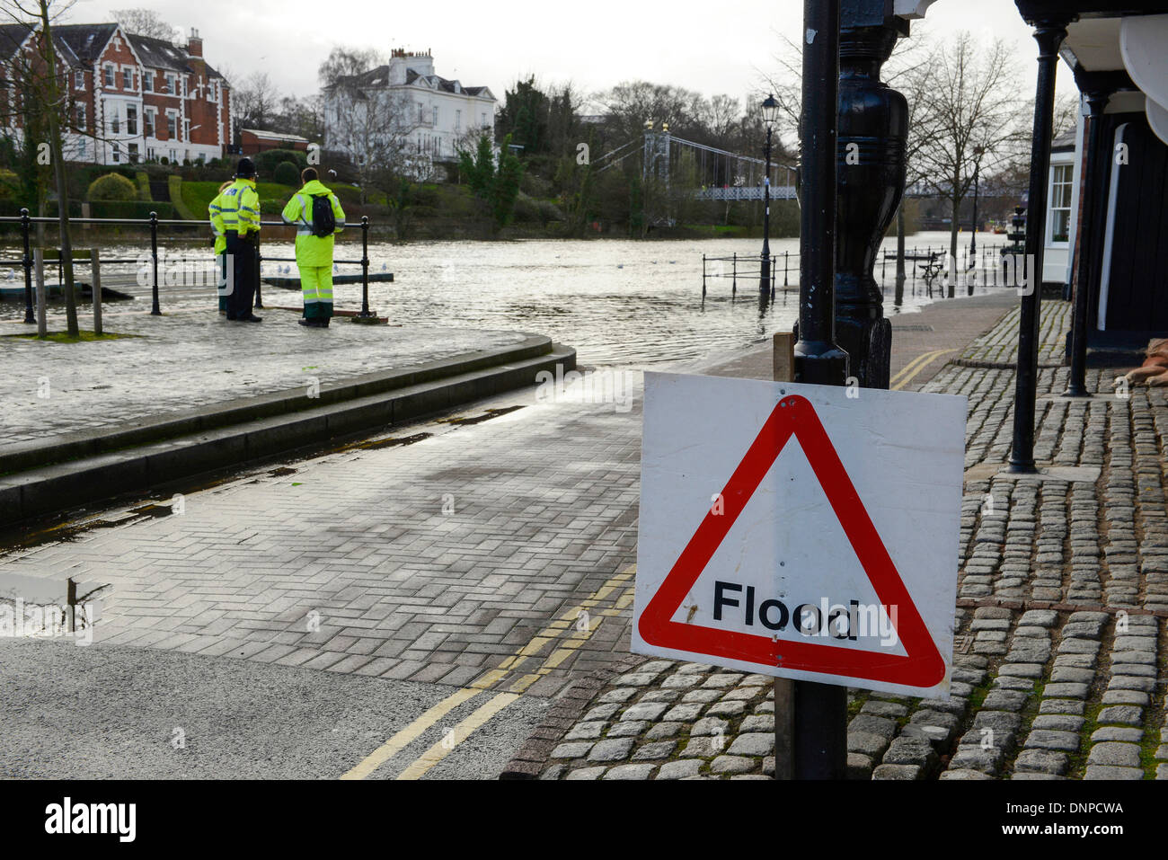 Polizei und Umweltagentur Arbeitnehmer überwachen die Hochwasser und Überschwemmungen auf den Fluss Dee in The Groves in Chester Stadtzentrum. Stockfoto