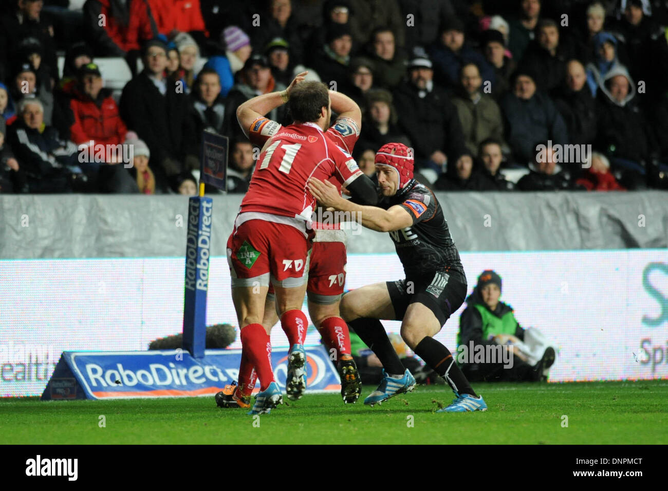 Swansea, Großbritannien. 3. Januar 2014. RaboDirect Pro12 - Fischadler V Scarlets - 3. Januar 2014 Scarlets Frazier Climo von Fischadler Richard Fussell angegangen ist. Bildnachweis: Phil Rees/Alamy Live-Nachrichten Stockfoto