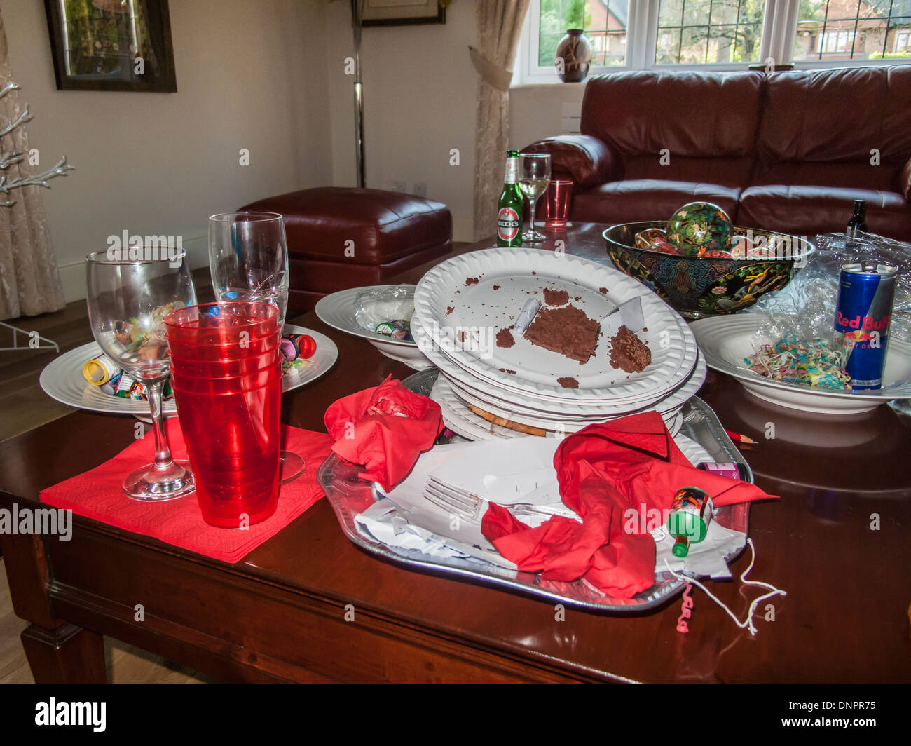 Chaos nach einer festlichen Jahreszeit Party - schmutzige Pappteller, Plastikbecher, verworfen Servietten, leere Gläser, Getränke Dose und Flasche Stockfoto