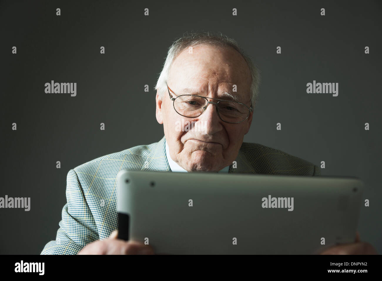 Älterer Mann mit Tablet-Computer im Studio Stockfoto