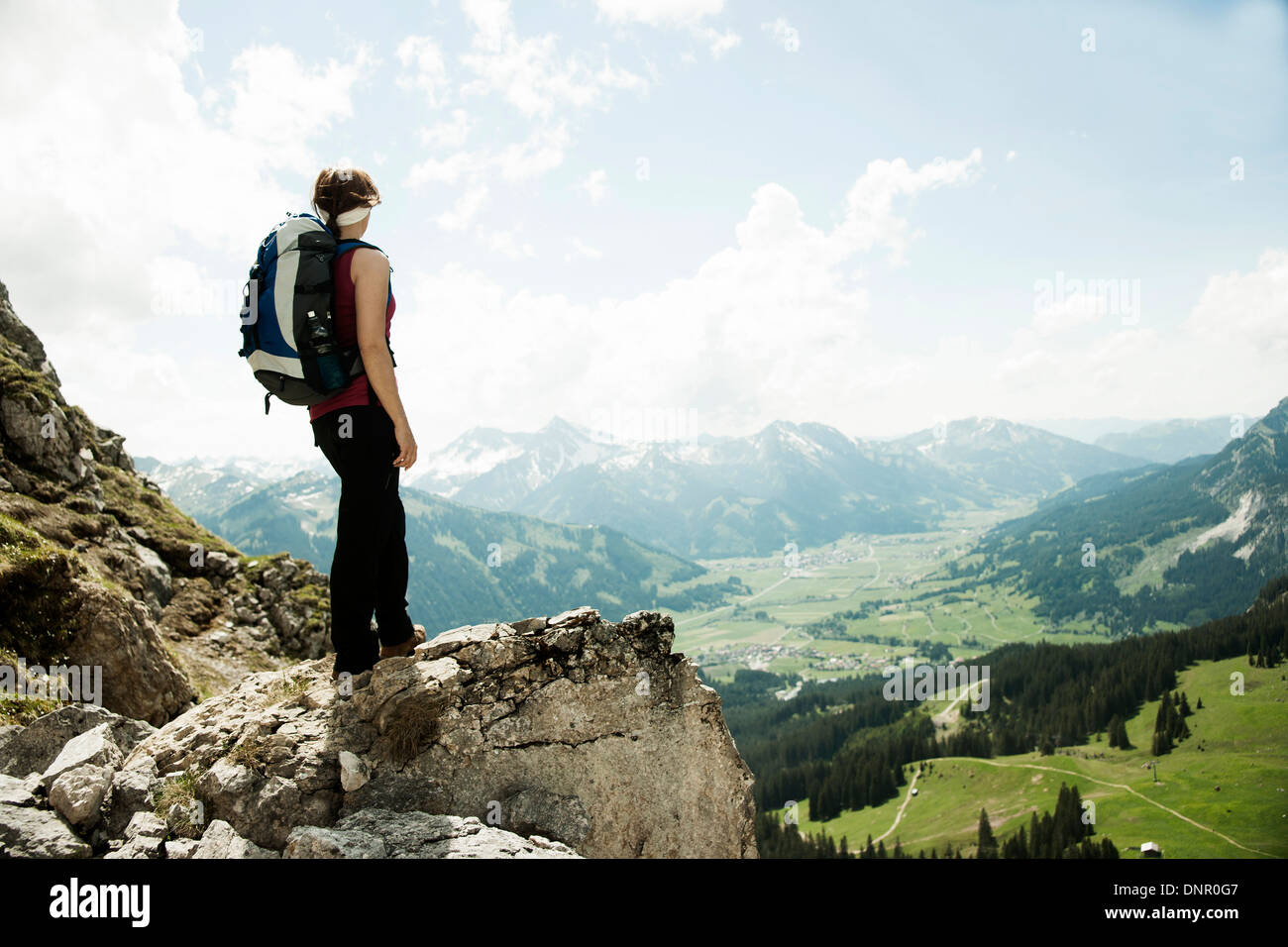 Reife Frau steht auf Klippe, Wandern in Bergen, Tannheimer Tal, Österreich Stockfoto