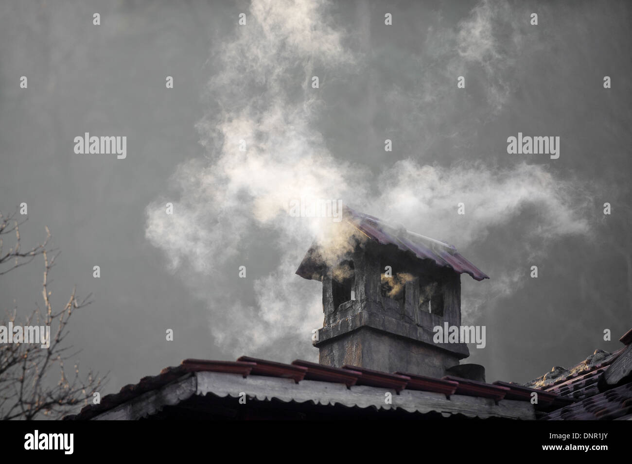 Haus mit Schornstein Rauchen in einem kalten Wintertag Stockfoto