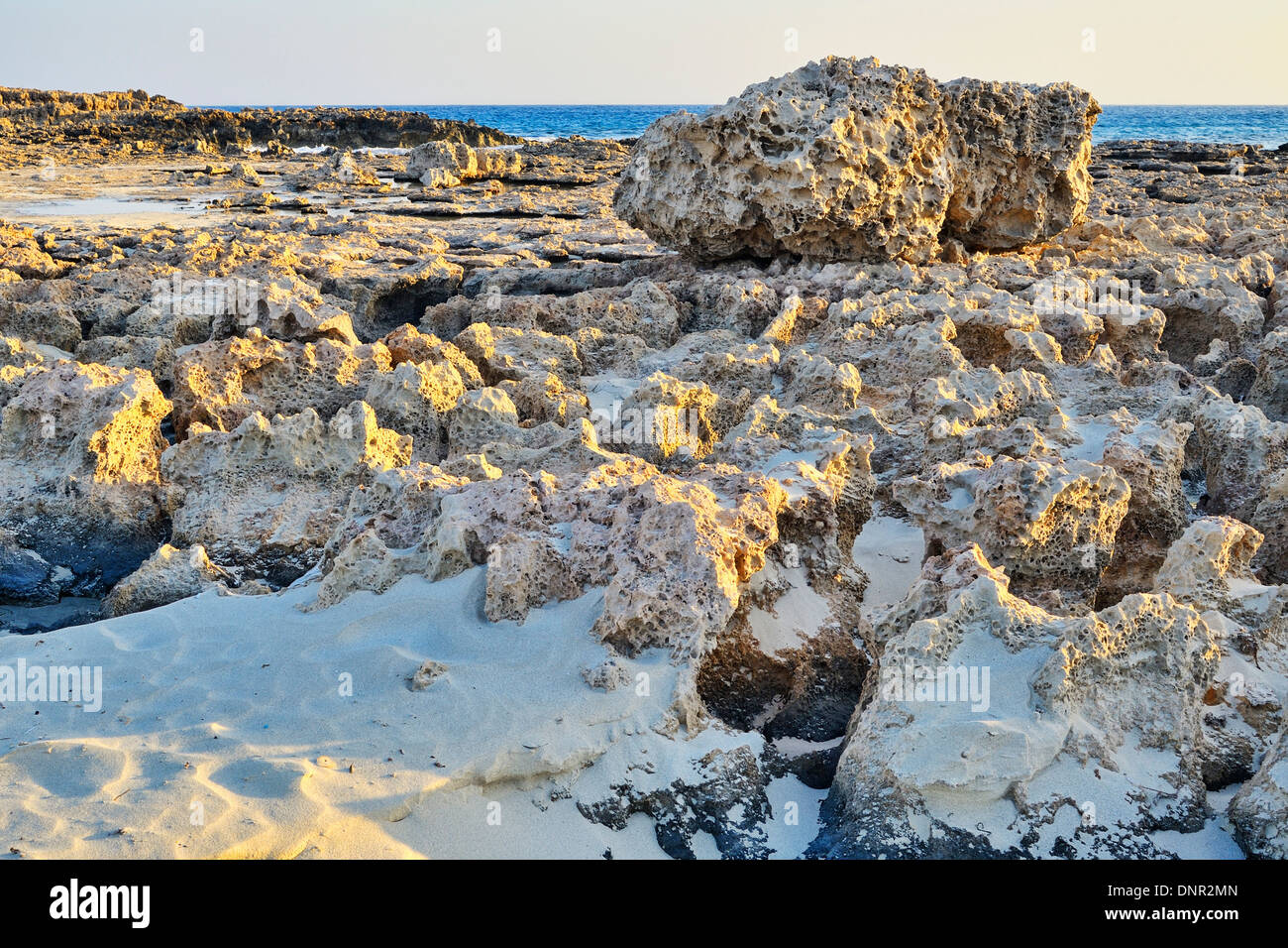 Die untergehende Sonne bescheint eine Felsformation im Nissi Beach in Ayia Napa, Zypern. Stockfoto